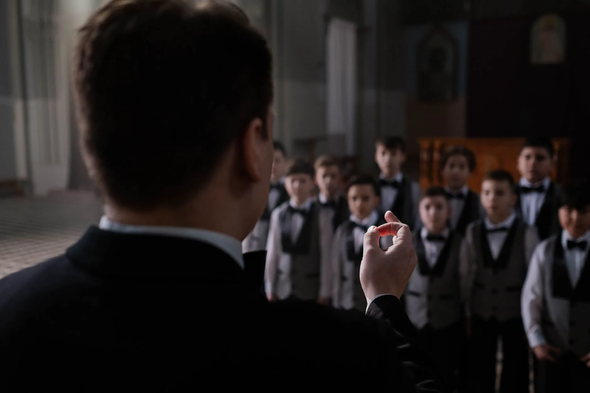 Young singer in historic choir training, muted tones, soft light, ordinary film style.