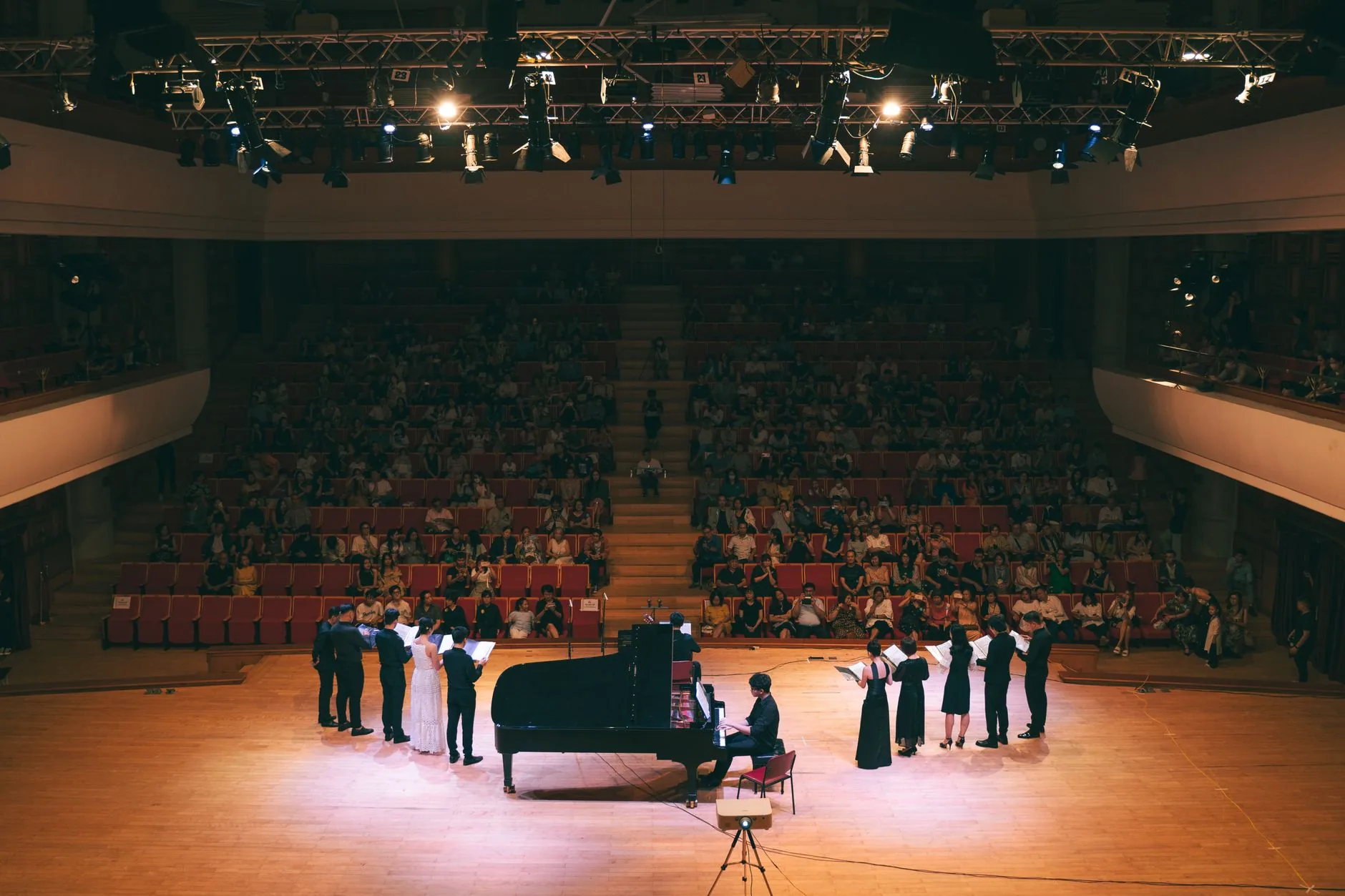 Young choir member in warm, soft light during rehearsal. Osvaldo Golijov choral compositions.