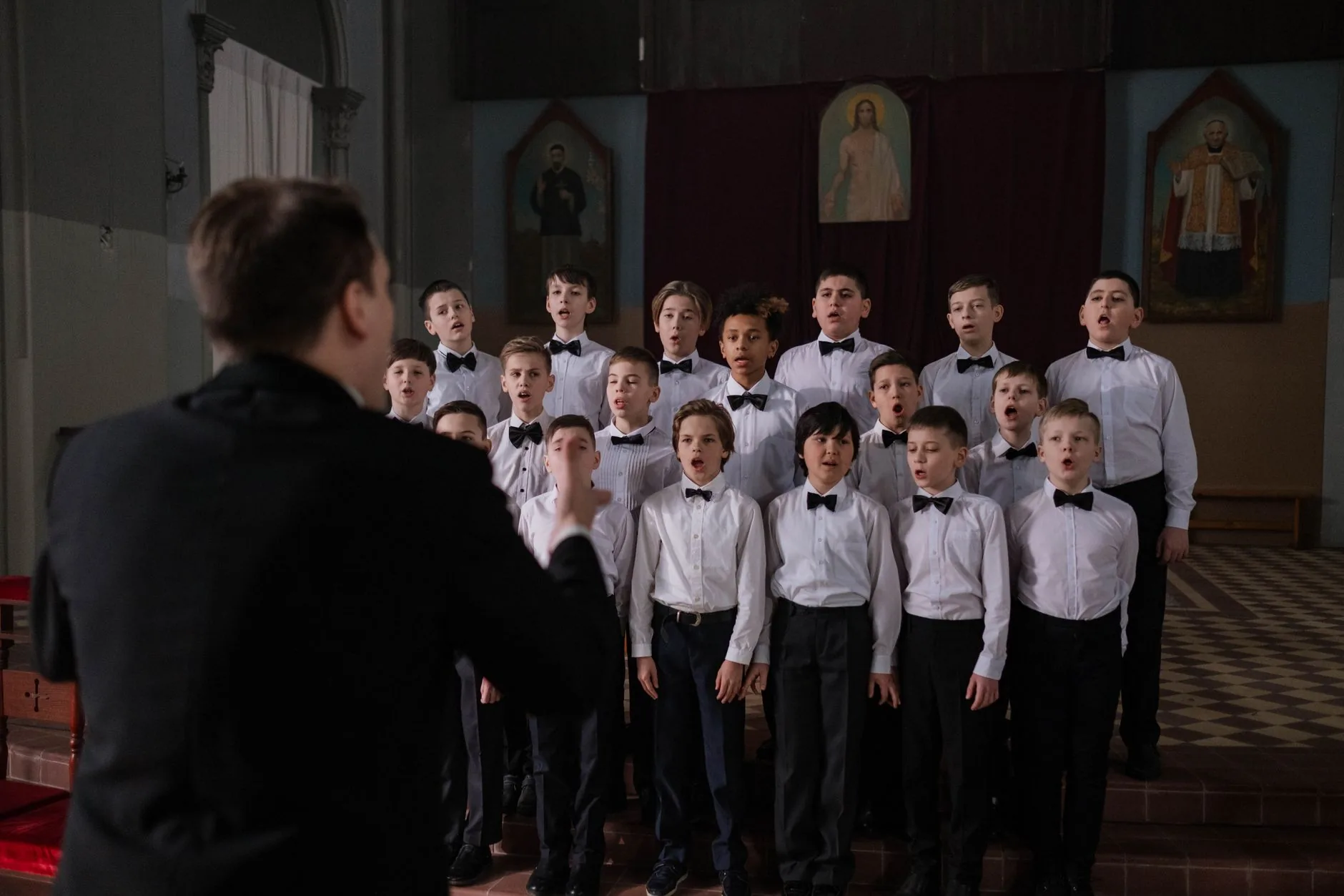 Young girl singing in sunlit rehearsal room, flower songs audio.